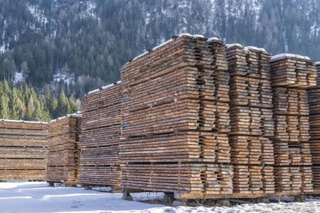 锯木板干燥木材板在冬季阿尔卑斯山区的锯木厂照片